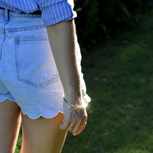 Femme portant un jonc rectangulaire en vermeil au poignet.