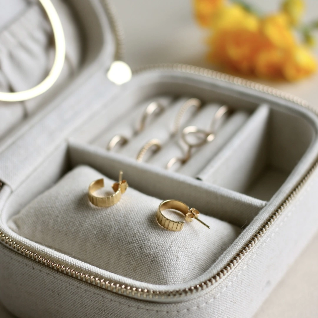 Boîte à bijoux avec une paire de boucles d'oreilles crantées en or 